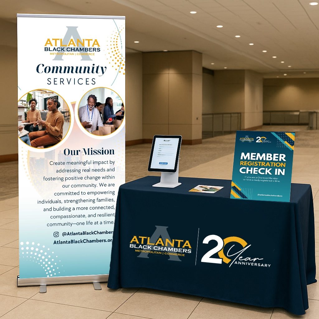 Atlanta Black Chambers Community Services event setup with a branded banner, tablecloth, and member registration sign
