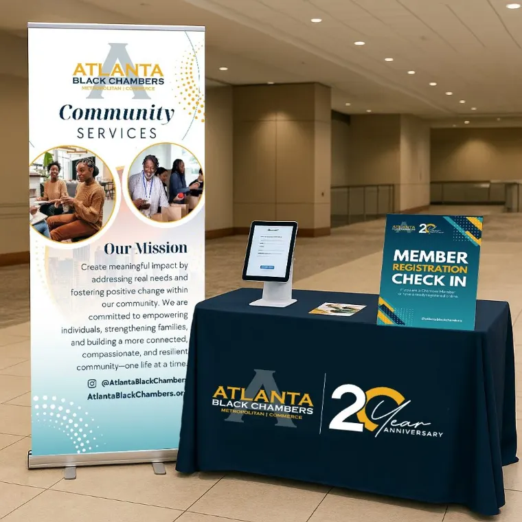 Atlanta Black Chambers Community Services event setup with a branded banner, tablecloth, and member registration sign