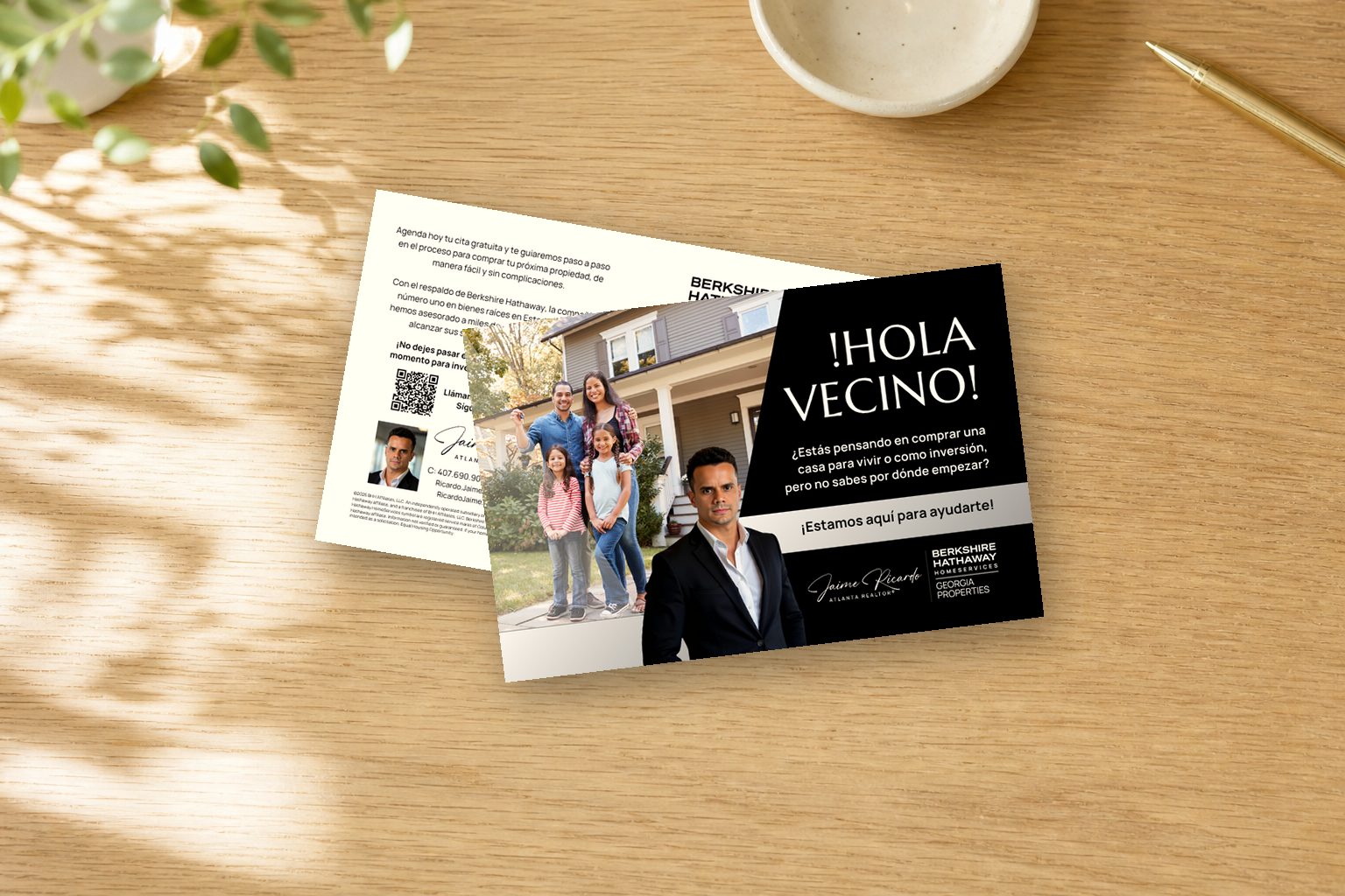Hola Vecino Spanish-language postcard mockup for Jaime Ricardo, front and back shown together on an oak desk